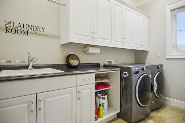 laundry room with cabinets, washing machine and dryer, and sink