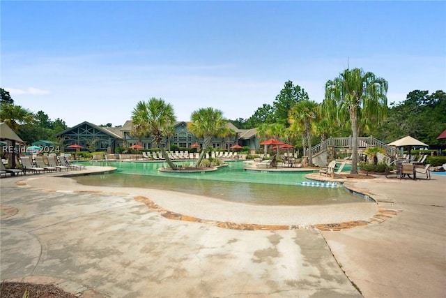 view of property's community with a pool and a patio