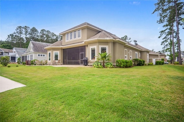 rear view of house featuring a yard and a sunroom