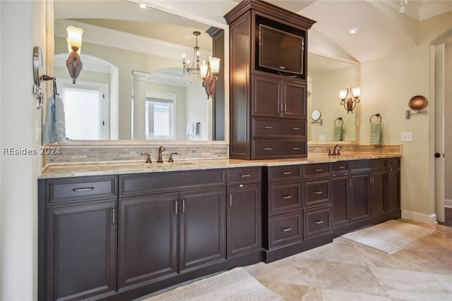 bathroom with decorative columns, vanity, and crown molding