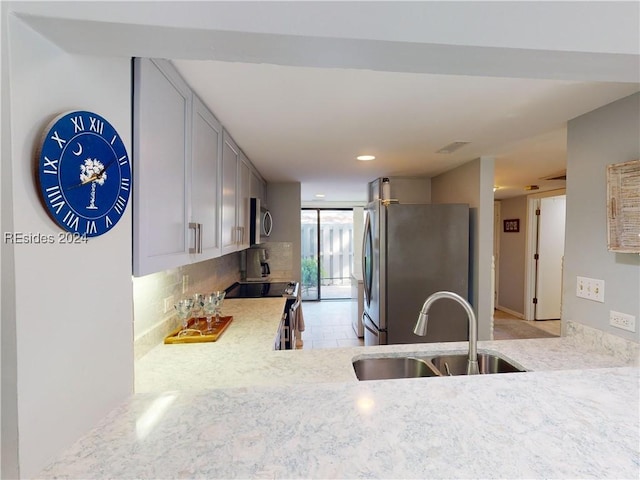 kitchen featuring stainless steel appliances, tasteful backsplash, and sink