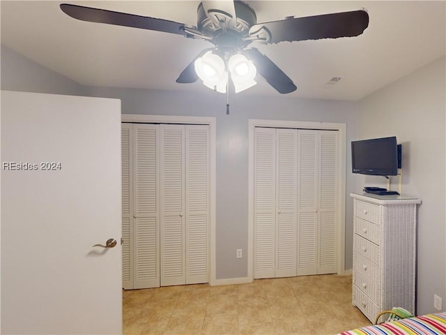 bedroom with multiple closets and ceiling fan