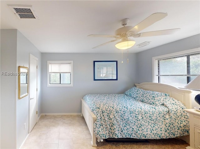 tiled bedroom featuring ceiling fan