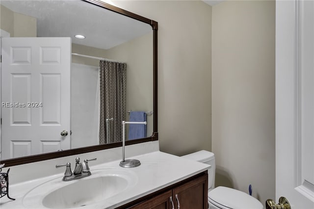 bathroom featuring vanity, toilet, and walk in shower