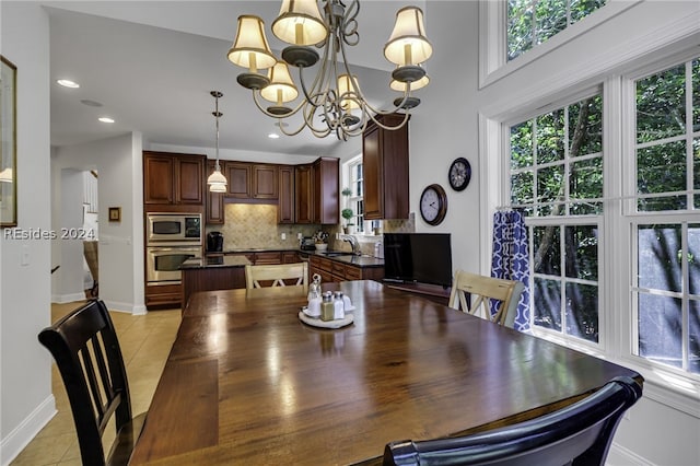 tiled dining area featuring sink and an inviting chandelier