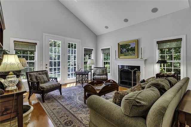 living room featuring hardwood / wood-style flooring, high vaulted ceiling, and a premium fireplace