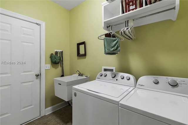 washroom featuring washing machine and dryer, sink, and dark tile patterned flooring