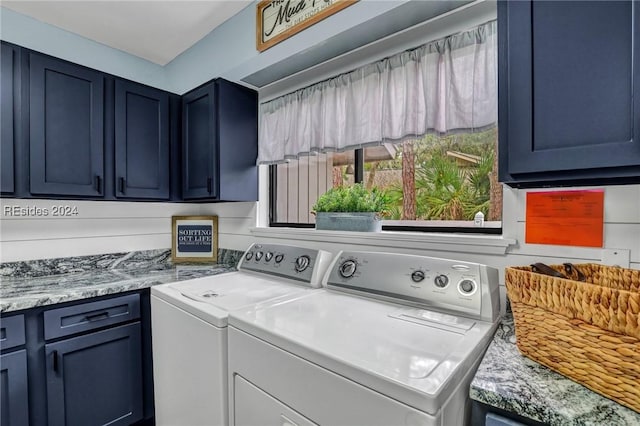 clothes washing area featuring separate washer and dryer and cabinets