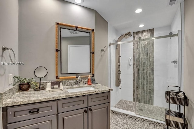 bathroom featuring vanity, a shower with shower door, and tile patterned flooring