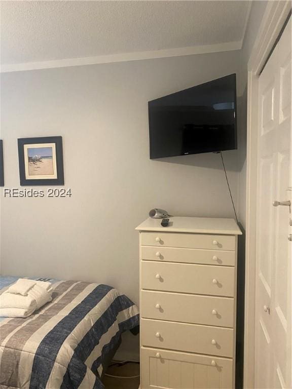 bedroom with ornamental molding and a textured ceiling