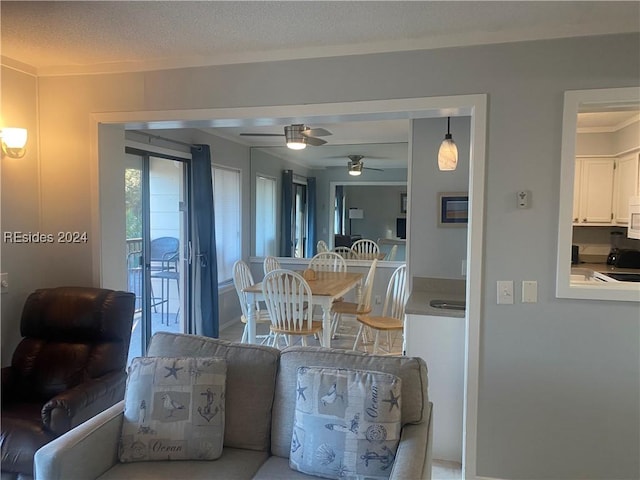 dining space featuring ceiling fan and a textured ceiling