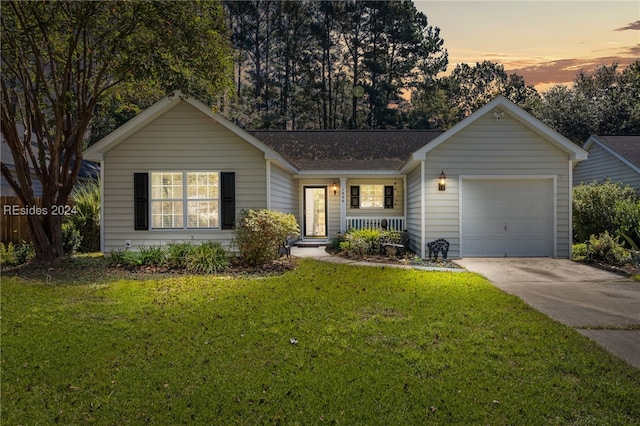 ranch-style house featuring a garage and a lawn