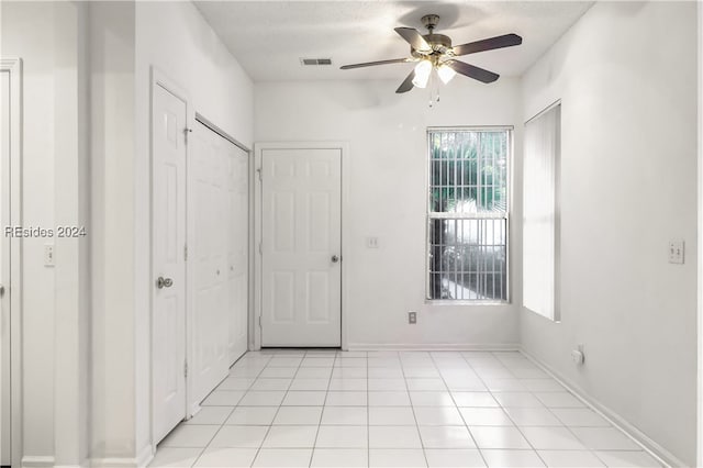 interior space with light tile patterned flooring and ceiling fan