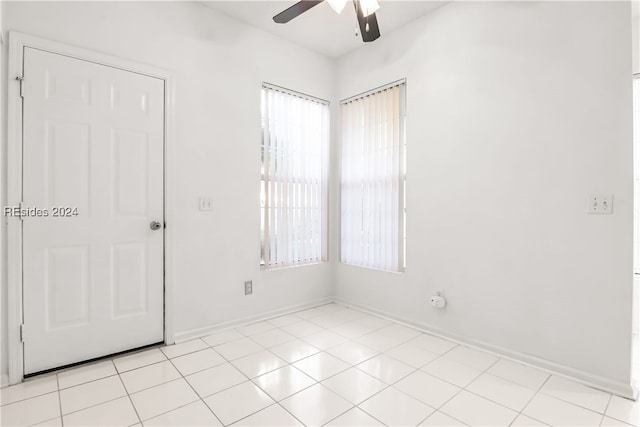 empty room featuring ceiling fan and light tile patterned floors