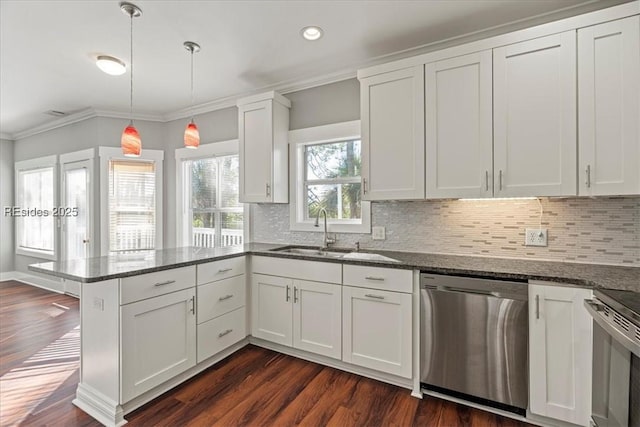 kitchen featuring sink, decorative light fixtures, appliances with stainless steel finishes, dark stone counters, and white cabinets