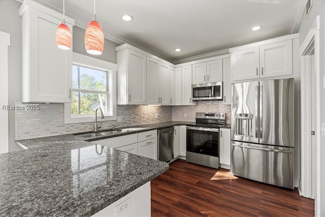 kitchen with decorative light fixtures, white cabinetry, sink, kitchen peninsula, and stainless steel appliances