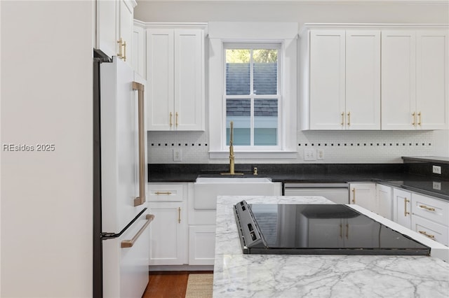 kitchen featuring dishwasher, sink, high end refrigerator, and white cabinets