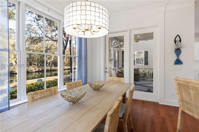 dining room featuring hardwood / wood-style flooring, ornamental molding, and a notable chandelier