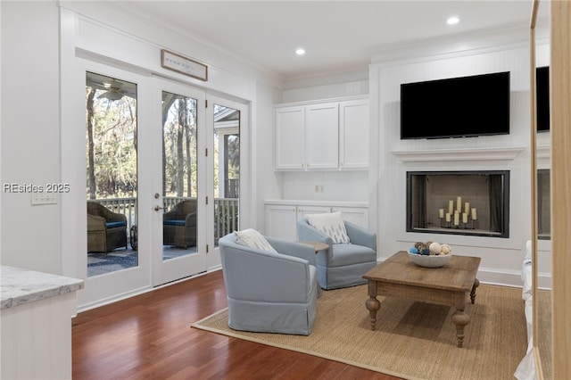 living area with crown molding, dark hardwood / wood-style floors, and french doors