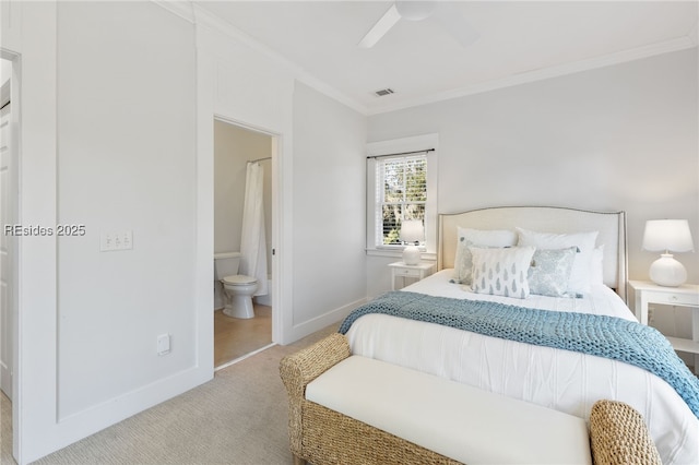 carpeted bedroom featuring ceiling fan, ornamental molding, and ensuite bath