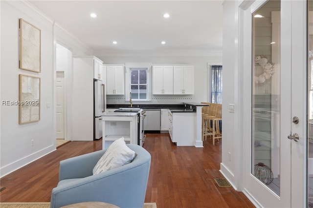 kitchen with white cabinetry, dark wood-type flooring, and crown molding