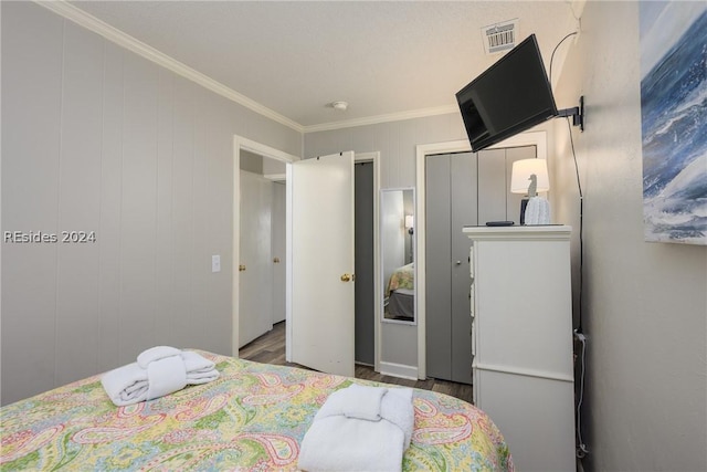 bedroom with ornamental molding and hardwood / wood-style floors