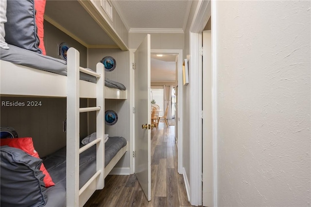 interior space featuring crown molding, wood-type flooring, and a textured ceiling