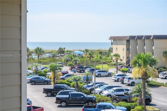 view of car parking featuring a water view