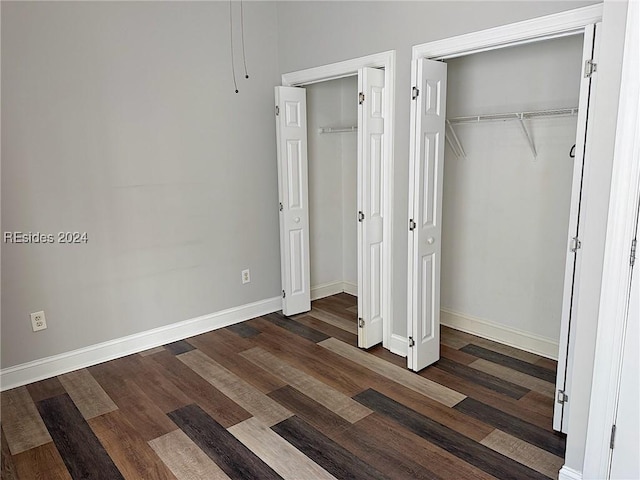 unfurnished bedroom with dark wood-type flooring and a closet