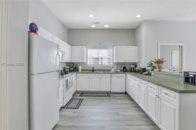 kitchen featuring white cabinetry, sink, light hardwood / wood-style floors, kitchen peninsula, and white appliances