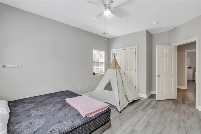 bedroom with ceiling fan, a closet, and light wood-type flooring