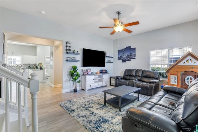 living room featuring ceiling fan and light hardwood / wood-style floors