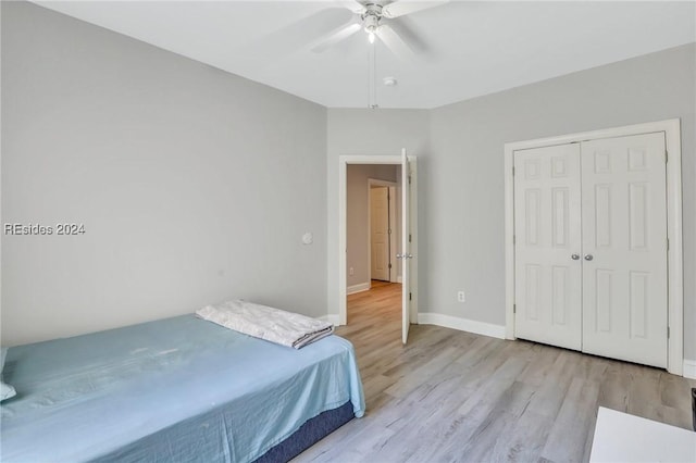 bedroom featuring light wood-type flooring, ceiling fan, and a closet