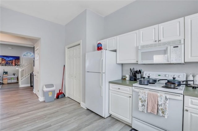 kitchen featuring white cabinets, white appliances, and light hardwood / wood-style floors