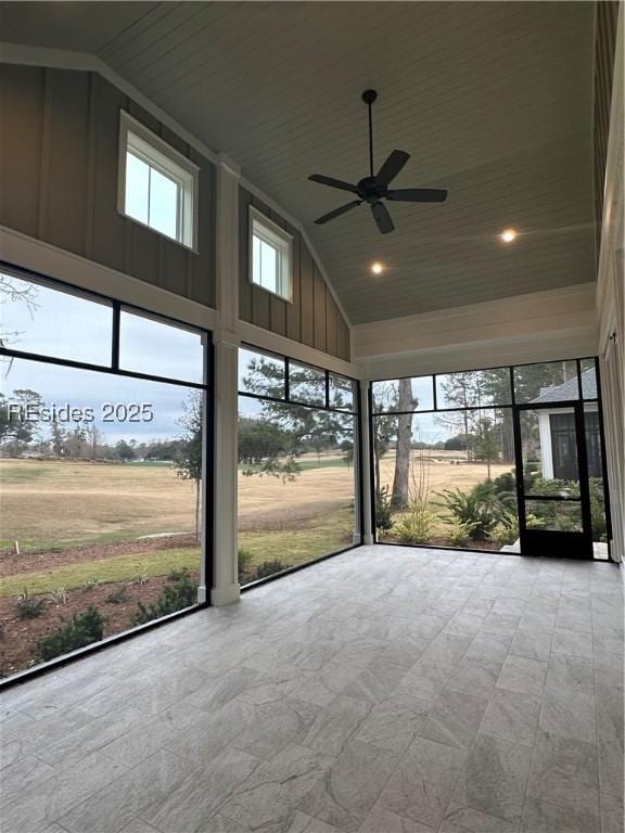 unfurnished sunroom featuring plenty of natural light, lofted ceiling, and a rural view