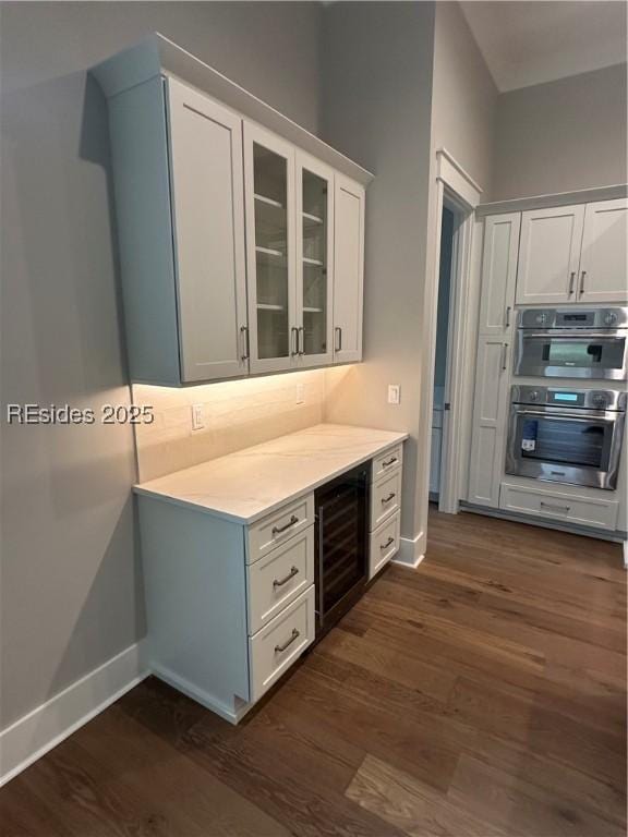 kitchen featuring white cabinets, dark wood-type flooring, wine cooler, and double oven