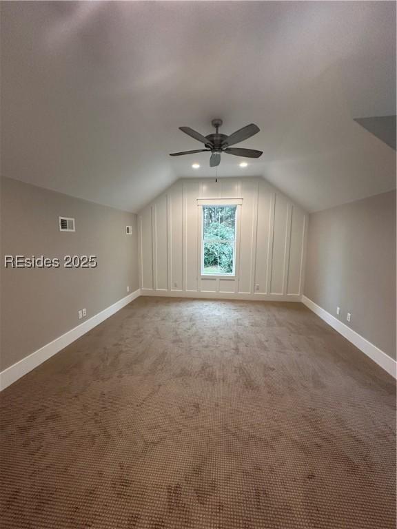 additional living space with lofted ceiling, carpet floors, and ceiling fan