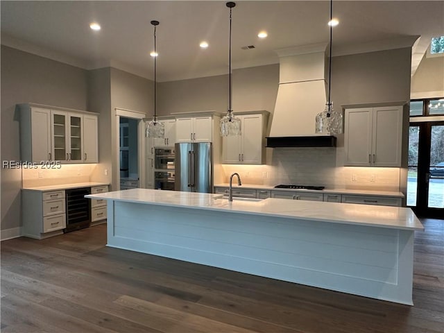 kitchen featuring white cabinetry, appliances with stainless steel finishes, decorative light fixtures, and sink