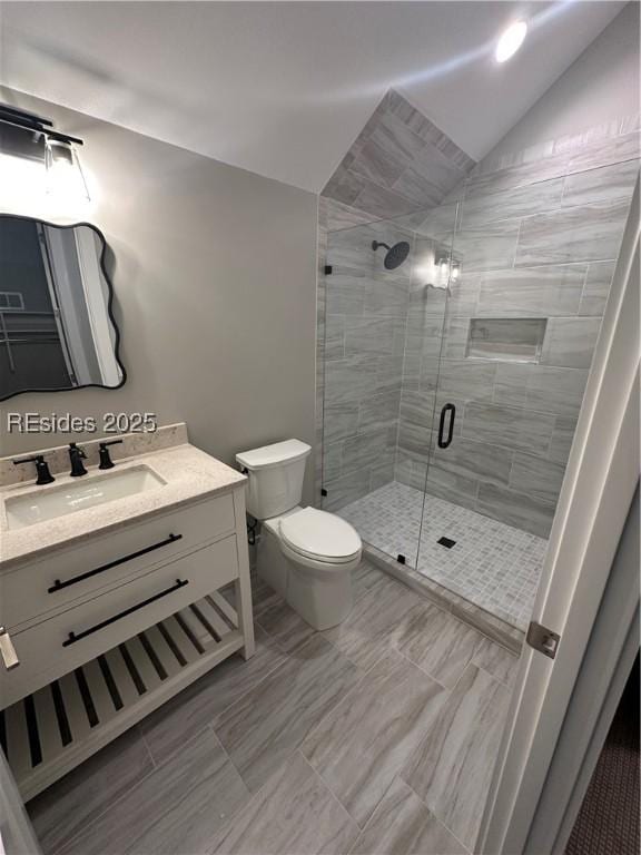 bathroom with vanity, vaulted ceiling, toilet, and walk in shower