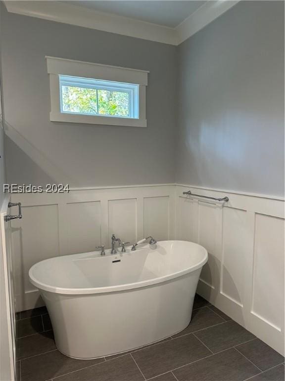 bathroom featuring crown molding, tile patterned floors, and a tub