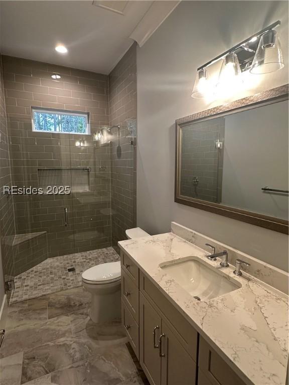 bathroom featuring vanity, toilet, and an enclosed shower