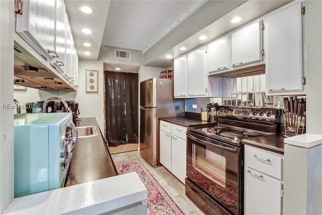 kitchen with stainless steel refrigerator, black range with electric stovetop, and white cabinets