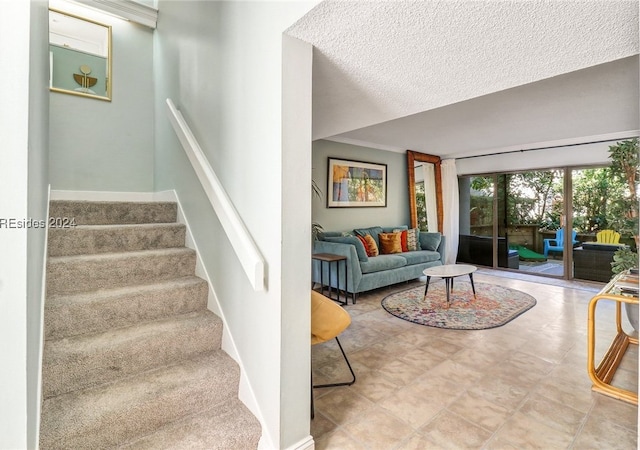 staircase with ornamental molding and a textured ceiling