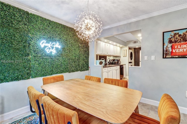 dining space featuring sink, an inviting chandelier, stacked washer and clothes dryer, ornamental molding, and a textured ceiling