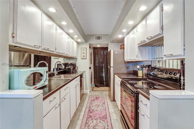 kitchen featuring white cabinetry, black electric range, and sink