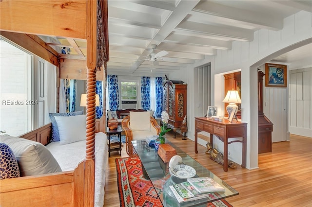 living room featuring beamed ceiling, wooden walls, ceiling fan, and light hardwood / wood-style flooring