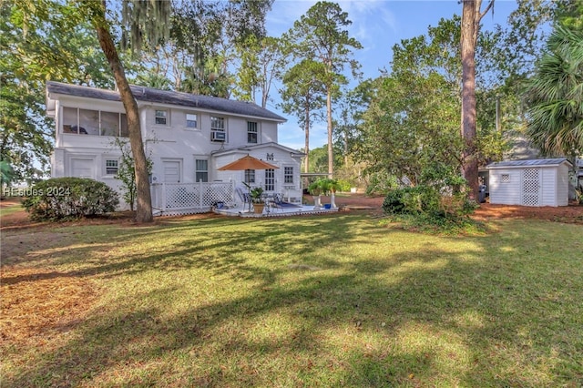 rear view of property with a wooden deck, a yard, and a storage unit