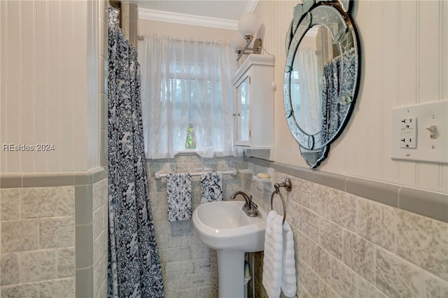 bathroom with ornamental molding and tile walls