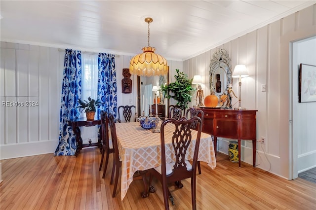 dining area with ornamental molding and light wood-type flooring