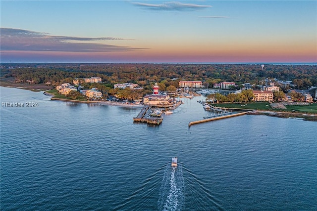 aerial view at dusk featuring a water view